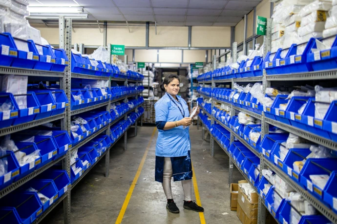 A worker stands in a warehouse filled with supplies